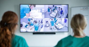 Different camera perspectives displayed on a monitor during a video debriefing.